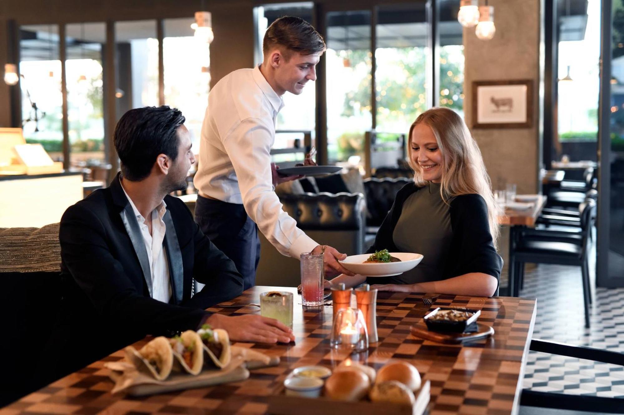 La Ville Hotel & Suites City Walk Dubai, Autograph Collection Exteriör bild A waiter serving a couple